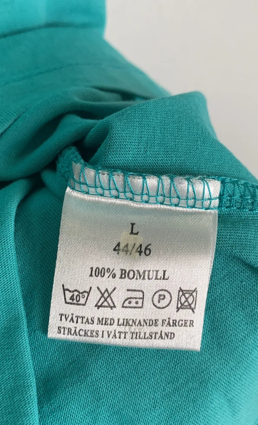 Teal t-shirt med blommig spetsdetalj bak